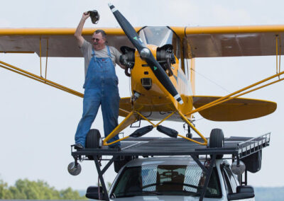 plane on top of truck with man standing next to the plane